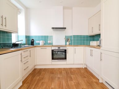 A kitchen with cabinets and appliances at The Old Bank Flat North Tawton