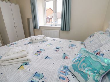 A bedroom with a bed and towels on the covers at Harbour View Poole