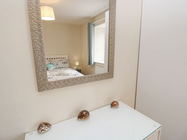 A bedroom with a mirror and bed at Harbour View Poole in Poole