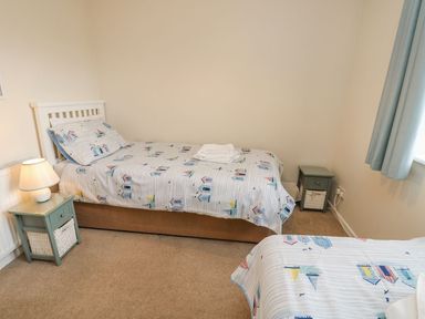 A bedroom with two beds and a bedside table at Harbour View Poole
