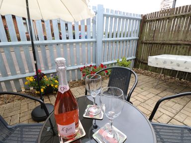 An outdoor seating area with a bottle and glasses at Harbour View Poole