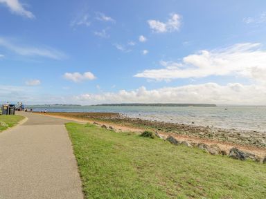 A pathway by the water with people at Harbour View Poole in Poole