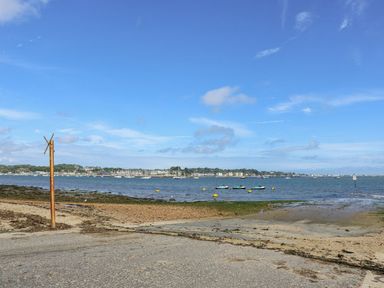 A beach with boats on water at Harbour View Poole