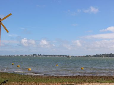 An outdoor view with a windmill and boats on the water at Harbour View Poole