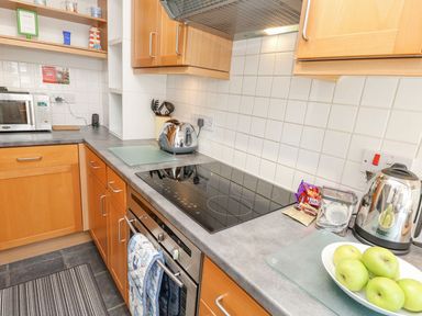 A kitchen with appliances and utensils at Poole Quay Cottage in Poole