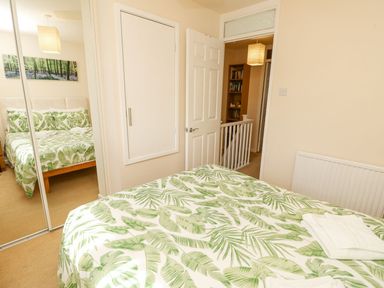 A bedroom with a bed and wardrobe at Poole Quay Cottage in Poole