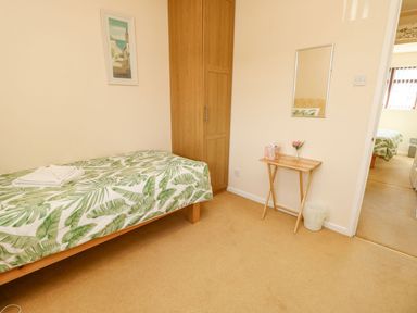 A bedroom with a single bed and a table at Poole Quay Cottage in Poole
