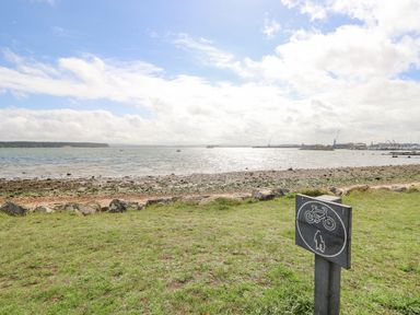 A coastal area with a sign and water at Poole Quay Cottage in Poole