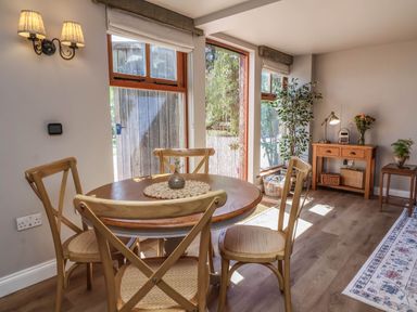A dining room with a table and chairs at Captains Barn in Tiverton
