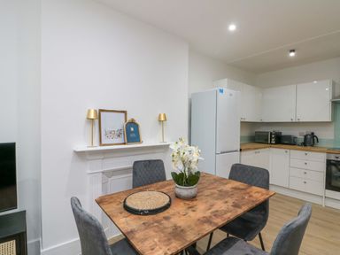 A kitchen with a table and chairs at Beachwalk Villa 2 in Whitby