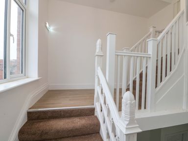 A staircase with a landing and windows at Beachwalk Villa 2 in Whitby
