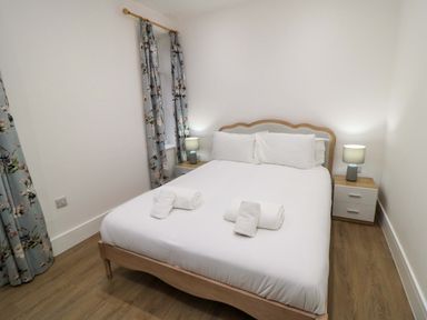 A bedroom with a bed and bedside tables at Beachwalk Villa 2 in Whitby