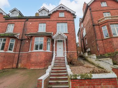 A brick building with steps and windows at Beachwalk Villa 2 Whitby