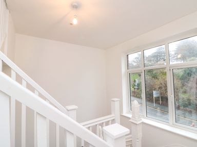 A staircase with a window and light fixture at Beachwalk Villa 3 in Whitby