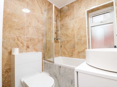 A bathroom with a bathtub and shower at Beachwalk Villa 3 in Whitby