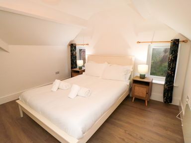 A bedroom with a bed and bedside tables at Beachwalk Villa 3 in Whitby