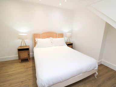 A bedroom with a bed and nightstands at Beachwalk Villa 3 in Whitby