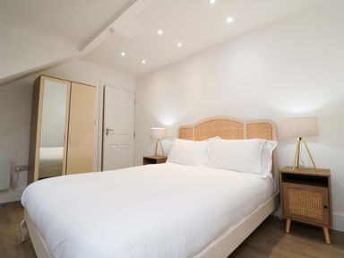 A bedroom with a bed and a wardrobe at Beachwalk Villa 3 in Whitby