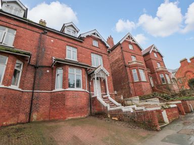 A red brick building with steps and windows at Beachwalk Villa 3 in Whitby