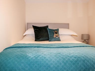 A bedroom with a bed and decorative pillows at Lannlyvri Lodge Lanlivery near Lostwithiel