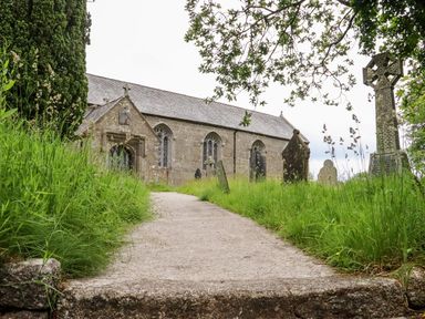 A church and gravestones with a pathway in front at Lannlyvri Lodge in Lanlivery near Lostwithiel