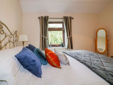 A bedroom with a bed and window at Camellia Cottage in Bodmin