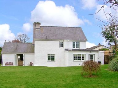 A house with a garden and seating area at Tyddyn Gyrfa Cottage Cemaes Bay