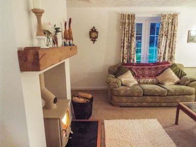 A living room with a couch and fireplace at Tyddyn Gyrfa Cottage Cemaes Bay