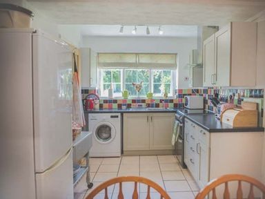 A kitchen with appliances and cabinets at Tyddyn Gyrfa Cottage in Cemaes Bay