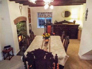 A dining room with a table and chairs at Tyddyn Gyrfa Cottage in Cemaes Bay