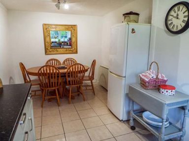 A kitchen with a dining table and chairs at Tyddyn Gyrfa Cottage in Cemaes Bay