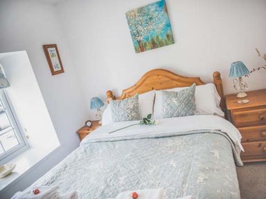 A bedroom with a bed and bedside tables at Tyddyn Gyrfa Cottage in Cemaes Bay
