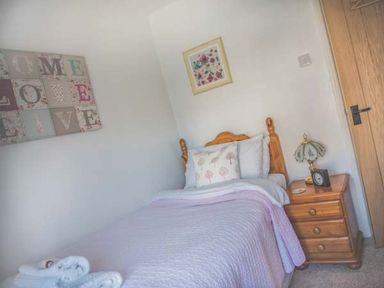 A bedroom with a bed and bedside table at Tyddyn Gyrfa Cottage in Cemaes Bay