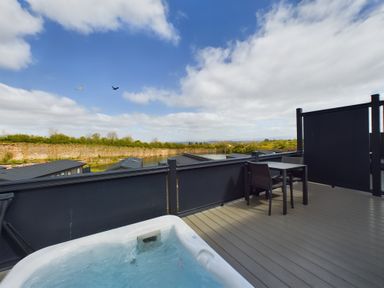 An outdoor area with a hot tub and table at Coniston (Pet) Penrith