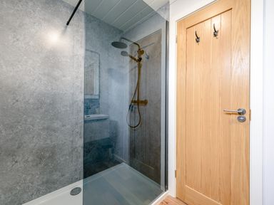 A bathroom with a shower and mirror at Coniston (Pet) Penrith
