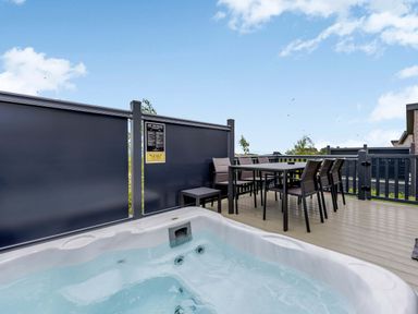 An outdoor area with a hot tub and a dining table at Blencathra Family in Penrith
