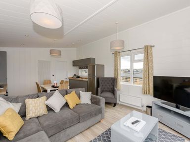 A living room with a sofa and dining table at Blencathra Family in Penrith