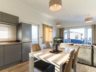 A kitchen and living room with a dining table and sofa at Grasmere in Penrith