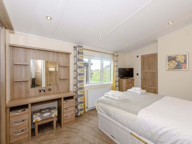A bedroom with a bed and dressing table at Keswick in Penrith