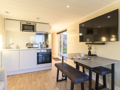 A kitchen with a dining table and appliances at Pods by the Lake in Penrith