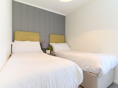 A bedroom with two beds and a bedside table at Grasmere (Pet) Penrith