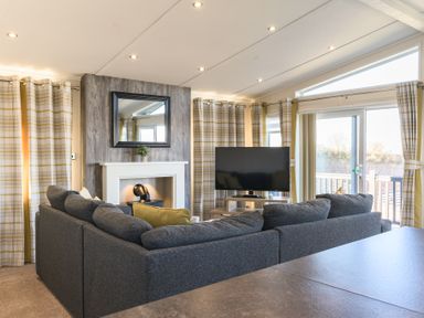 A living room with a sofa and television at Keswick (Pet) Penrith