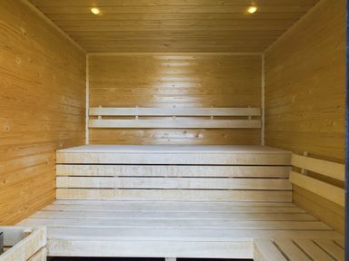 A sauna room with wooden benches and walls at Spa Sauna Lodge in Penrith