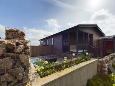 A house with outdoor seating and a fire pit at Spa Sauna Lodge (Pet) Penrith