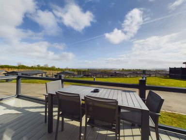 A terrace with a table and chairs at Spa Sauna Lodge (Pet) Penrith