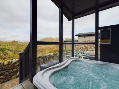A hot tub with a view of the outdoors at Spa Sauna Lodge (Pet) in Penrith