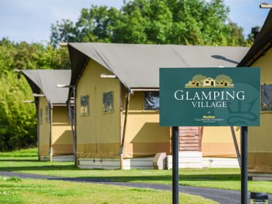 Sign for Glamping Village at Ullswater Heights with glamping tents in the background