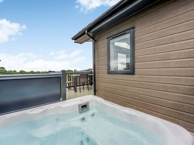 An outdoor area with a hot tub and decking at Helvellyn (Pet) Penrith