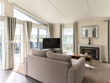 A living room with a sofa and television at Helvellyn (Pet) in Penrith