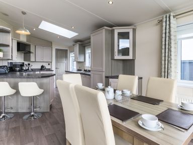 A kitchen with modern cabinets and dining area at Helvellyn (Pet) Penrith